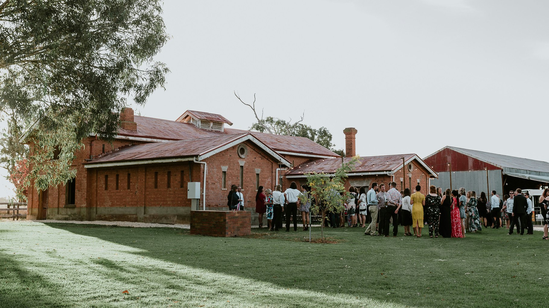 Wedding guests gather outside Mewburn Park's stables.